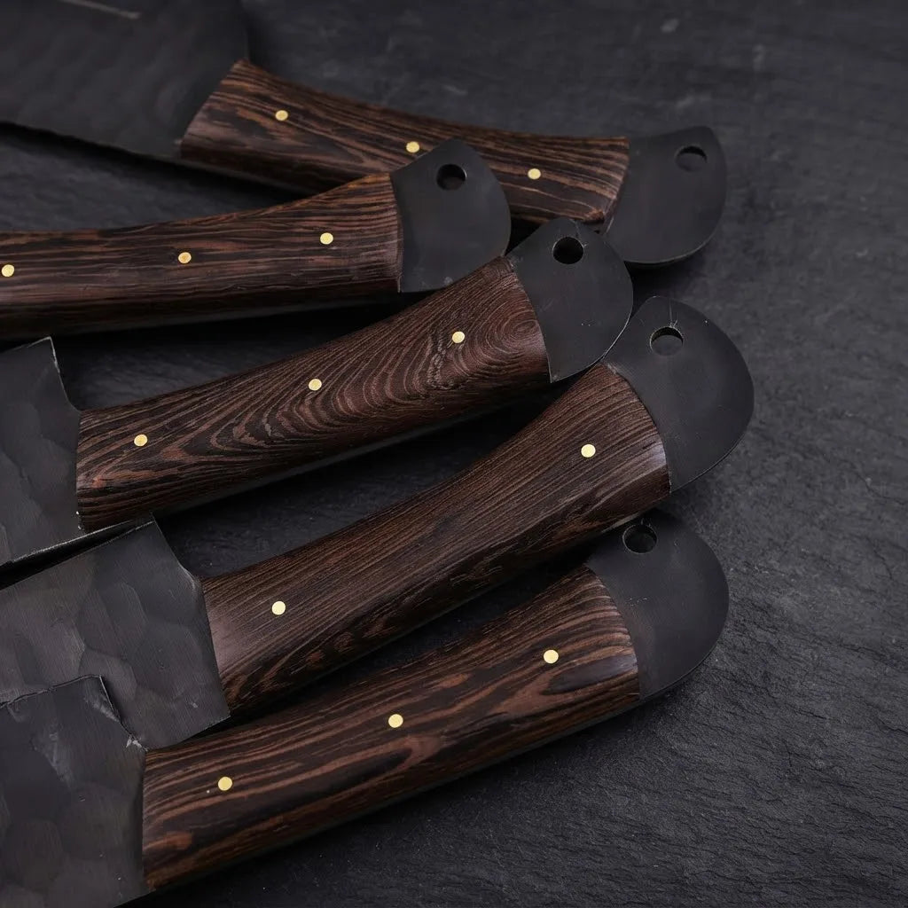 A close-up view of handcrafted culinary knife handles, featuring premium dark wood grain, brass pin detailing, and hammered steel bolsters, highlighting artisanal craftsmanship for professional kitchen decor.