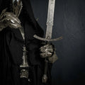 A close-up view of a knight's steel gauntlet holding a beautifully hand-forged Damascus steel longsword, styled in a dark fantasy aesthetic.
