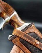 A premium handcrafted Damascus steel knife secured in a custom-fitted leather sheath with detailed wood handle.