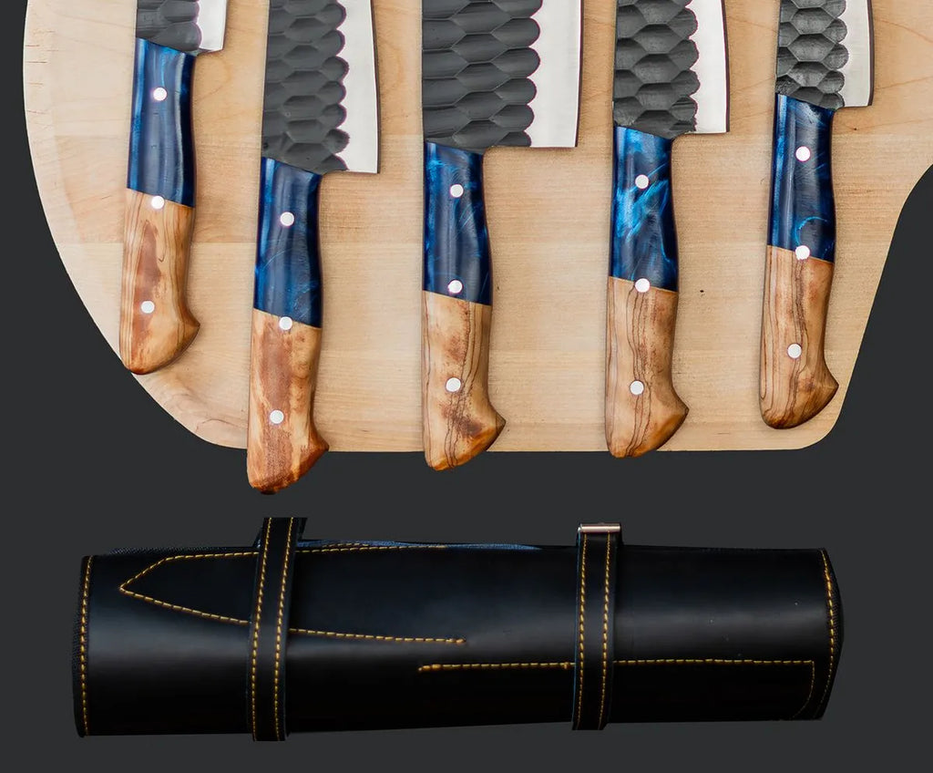 A premium 5-piece culinary knife set with hammered finish blades and blue resin/wood handles, displayed alongside a professional leather roll-up storage case.