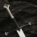 Close-up of a handmade medieval king's sword replica featuring intricate metalwork on the pommel and crossguard, with a leather-wrapped grip