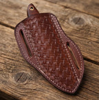 Close-up of a handmade Damascus steel cowboy hunting knife with an exquisite rosewood handle and vibrant turquoise inlay, resting on a rustic wooden surface.