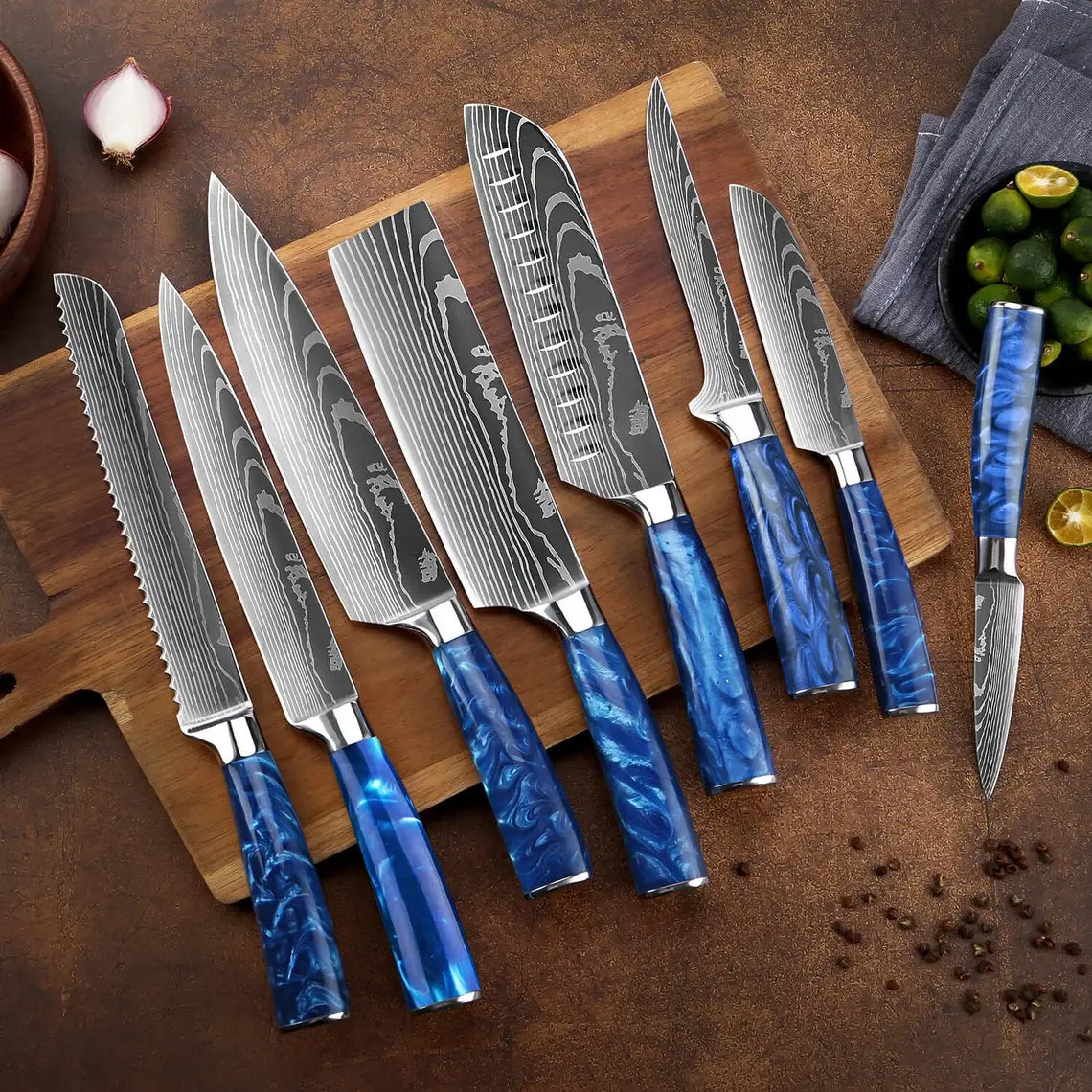 High-contrast Damascus steel kitchen knives with vibrant blue resin handles arranged on a wooden cutting board with fresh limes and onions on a textured rustic background.