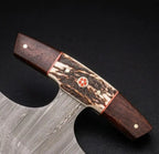 Premium custom Damascus hunting knife featuring an ergonomic antler and exotic wood handle handle with intricate mosaic pin detailing and wavy steel blade patterns for weapon collectors.