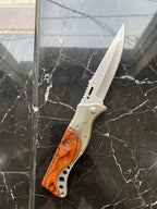 Premium custom EDC folding knife displayed open to show blade mechanics and full body profile, featuring durable stainless steel construction and a unique burls wood grip handle accent on a luxury stone background.