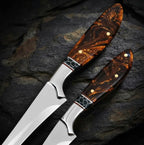 Close-up of a handmade fillet and boning knife set featuring exquisite, swirl-patterned resin handles with decorative honeycomb bolsters and brass pins.
