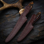 A professional handmade fillet and boning knife set safely stored in custom-tooled, embossed leather sheaths, perfect for fish and game processing.