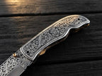 High-quality custom engraved pocket knife highlighting the deep relief metal carving and seamless bolster transition for collectors and gift buyers