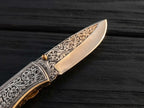High-quality custom engraved pocket knife showcasing intricate metal carving near the brass thumb stud and bolster for collectors and gift buyers