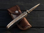 High-quality custom engraved pocket knife highlighting the detailed metal carvings along the back spine and blade for collectors and special occasion gifts