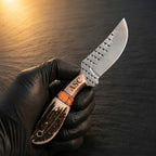A professional in-hand view of a handmade Western belt knife featuring a D2 rasp steel blade with ASC branding, genuine stag horn handle, and copper bolster on a dark background