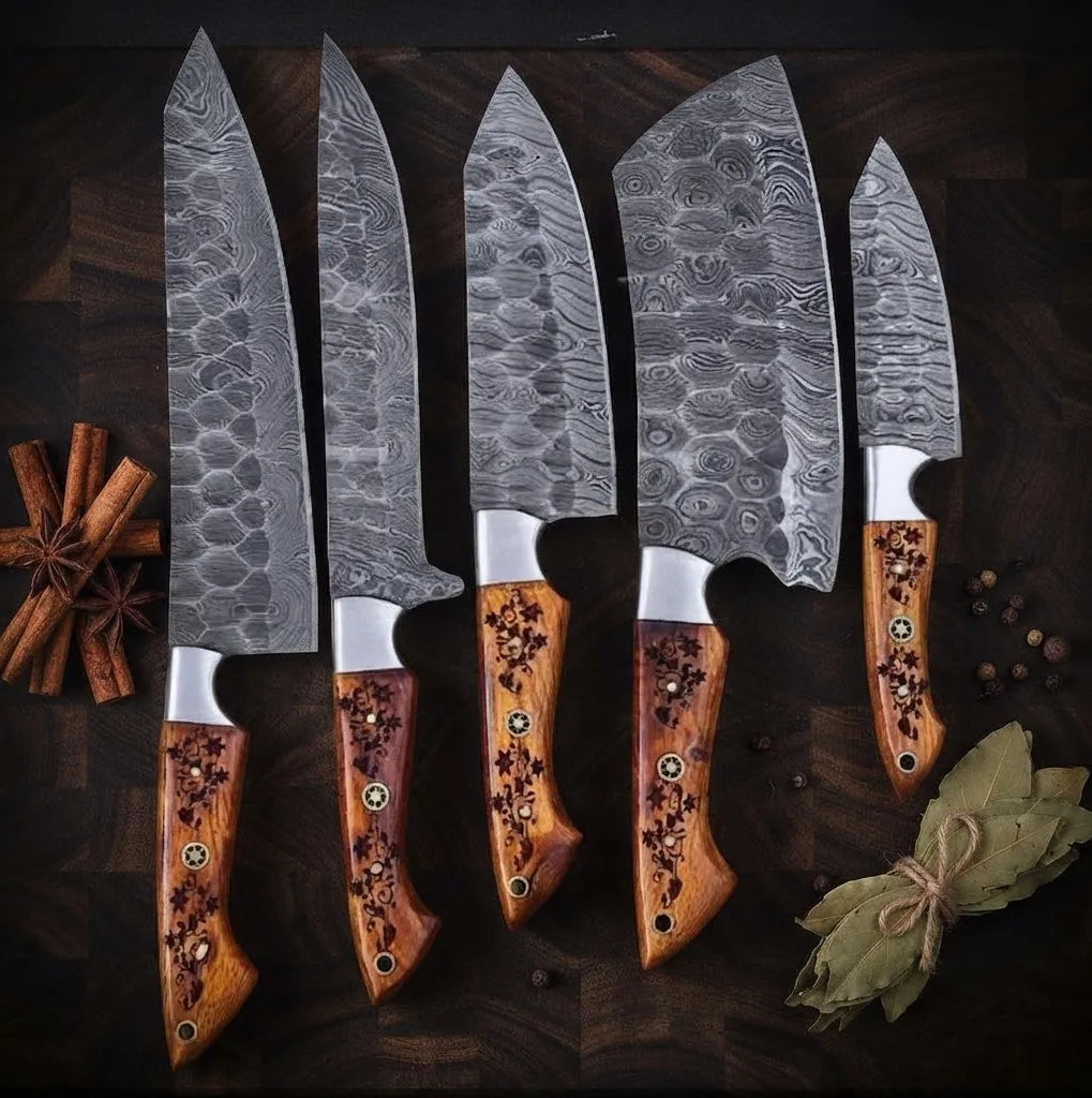 A set of luxury hand-forged Damascus steel kitchen knives featuring unique wavy blade patterns and intricate, hand-carved wooden handles, arranged with cinnamon and bay leaves