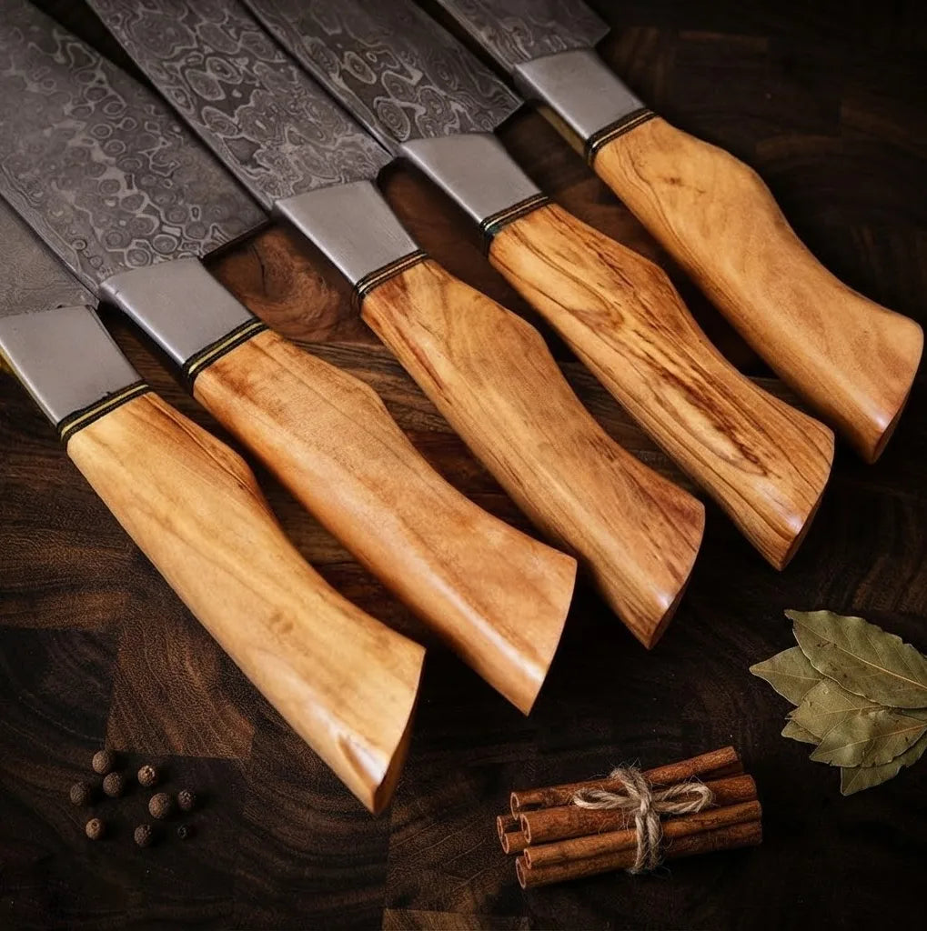 Close-up view of a premium Damascus steel kitchen knife set featuring ergonomic natural olive wood handles, showcasing the beautiful wood grain and expert craftsmanship.